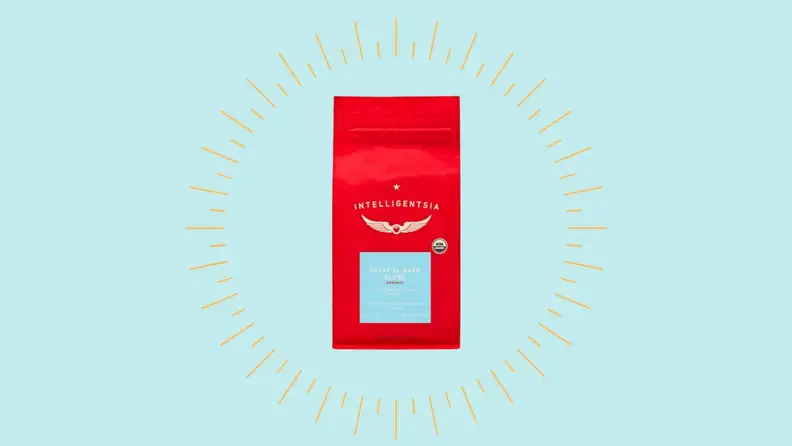 A bag of decaf coffee against a bright blue background.