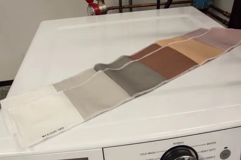 For stains, we use mechanically coated strips. They're covered in common household substances. Starting from the left those stains are: control, sweat, carbon, blood, cocoa, and red wine.