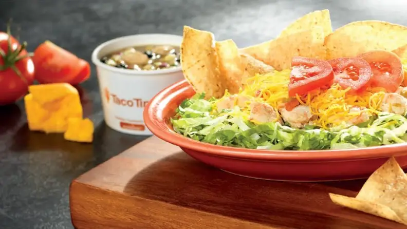 A taco salad with chips, cheese, and tomatoes