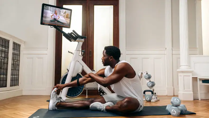 A man stretching next to the Myx II.