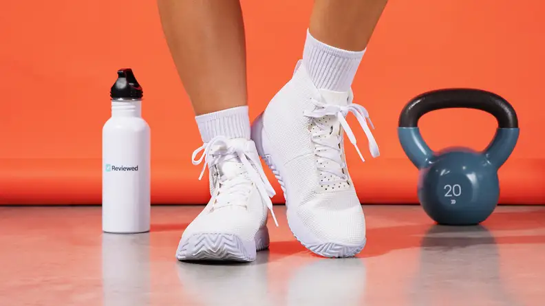 white sneakers next to 20 pound weight and water bottle