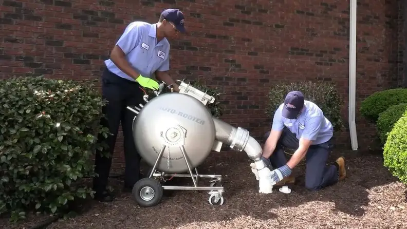Technicians setting up a large sewer cleaning machine outdoors