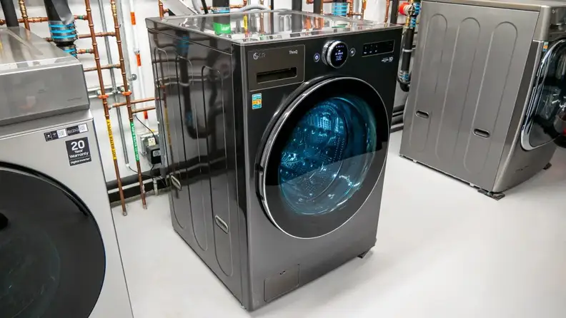 Angled photo of the front of an LG WM6700HBA front-load washing machine unit in the Reviewed testing laboratory.