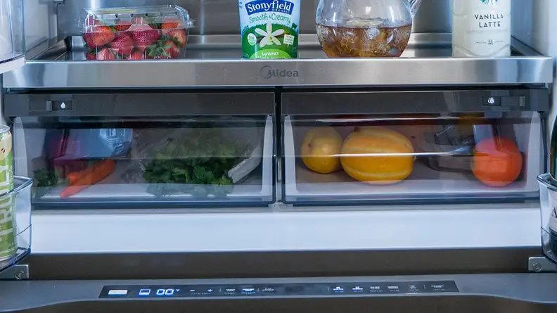Side by side crisper drawers with fruits and vegetables inside.