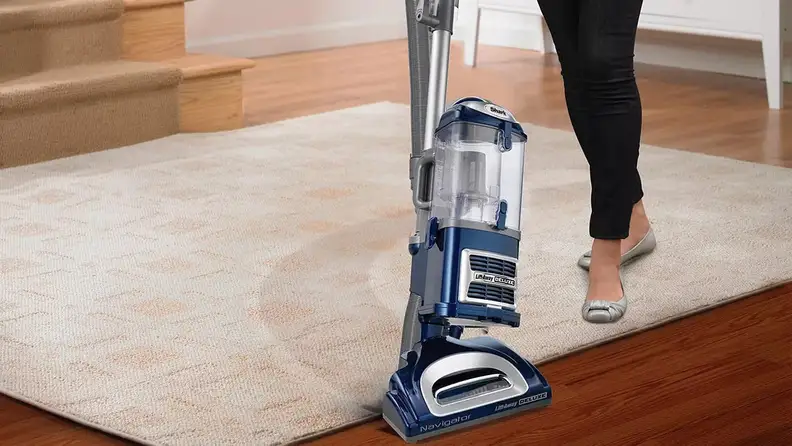 A person vacuums a rug.