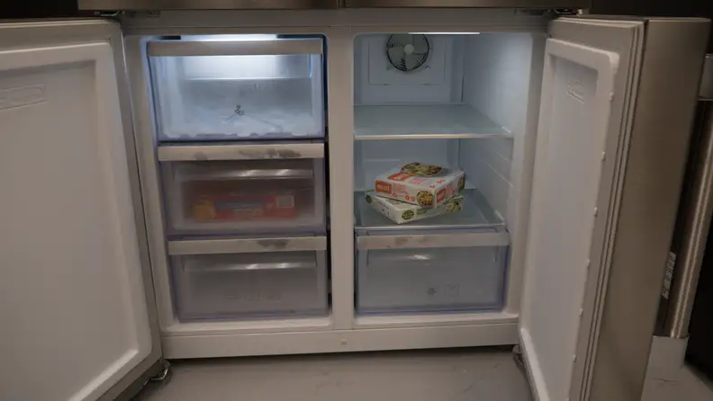 A close-up of the freezer. The left compartment has three drawers and the right compartment has one drawer underneath two shelves.