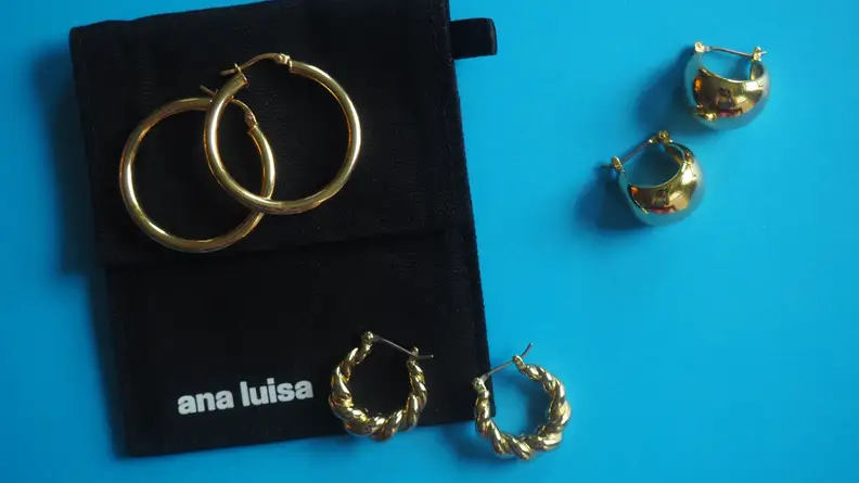 Ana Luisa gold earrings on blue background