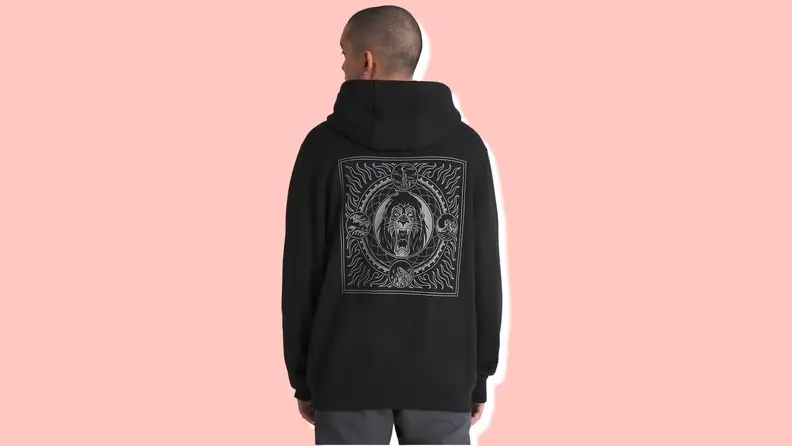 A man stands facing away from the camera, wearing a black hoodie sweatshirt with a graphic of Scar from "The Lion King"