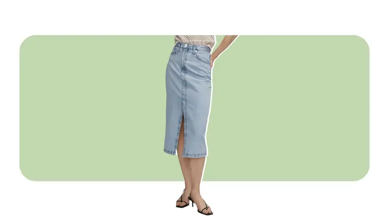 A model wearing a denim midi skirt with a slit in the front.