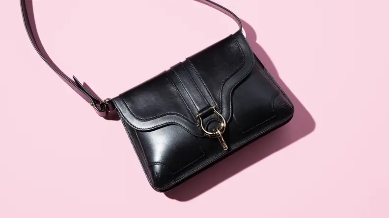 black shoulder bag on pink background