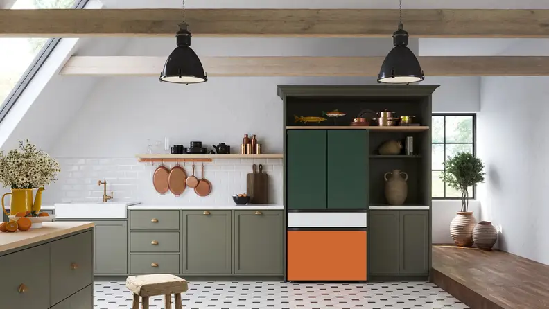The Samsung Bespoke fridge is installed into a modern kitchen. Its a French-door model with a flex drawer. The top two doors have a forest green finish, the flex drawer is white, and the freezer drawer is orange.