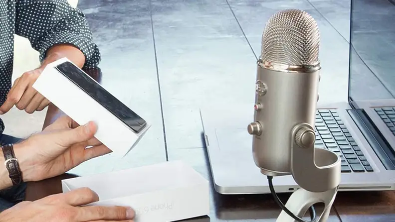 A person records with a blue yeti microphone.