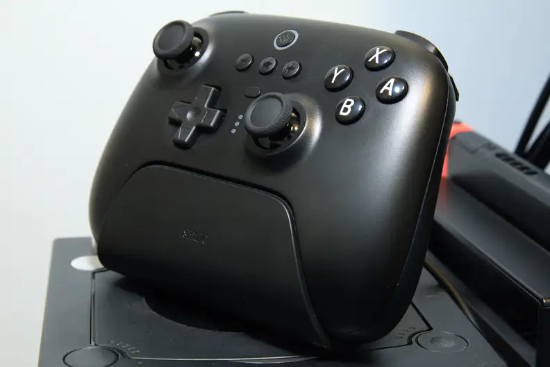A black controller sitting upright in a charging dock