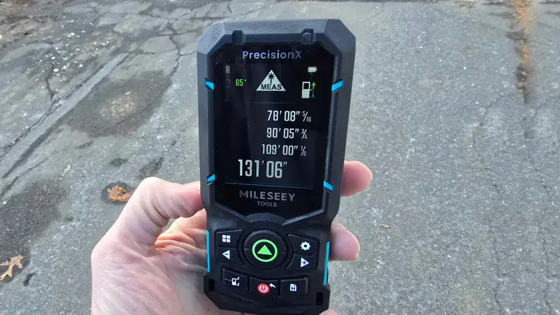 A hand holds a laser level