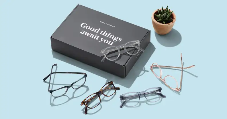 Warby Parker glasses on blue table next to box.