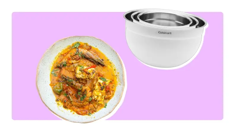 Plate of fish stew and pile of stainless steel mixing bowls on purple background