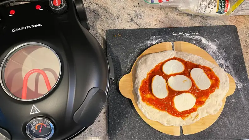 A pizza prepared next to the oven.