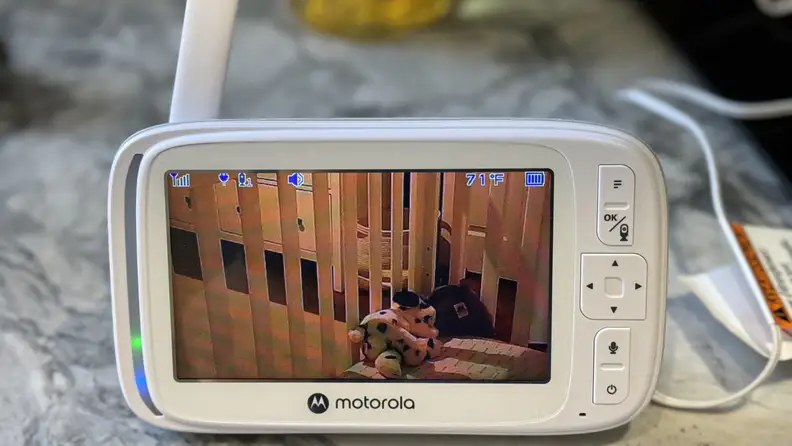 The baby monitor displaying a crib with a stuffed animal inside of it.
