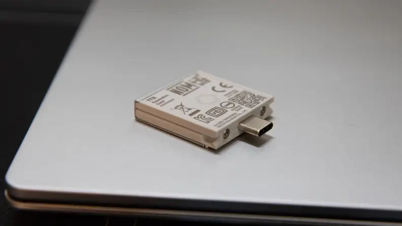 An expansion card lies on the laptop's lid.