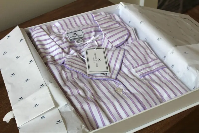 Purple and white Petite Plume pajama set inside the box