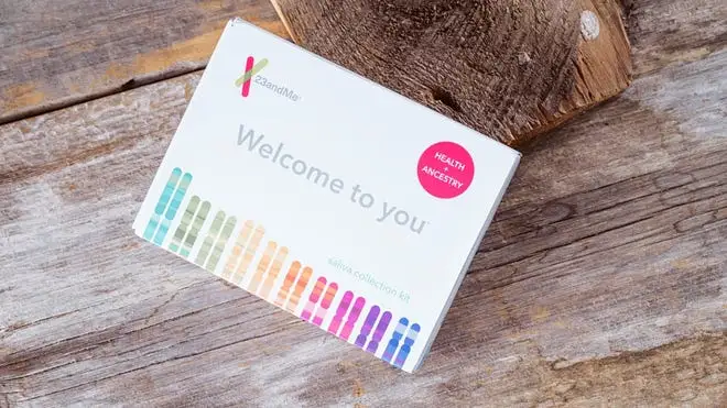 A 23andMe DNA test kit on a wooden table background.