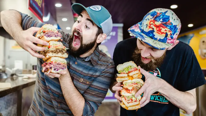Two men eating sandwiches