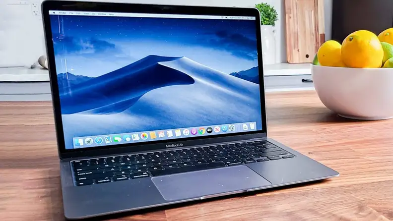A laptop sits on a dining table.