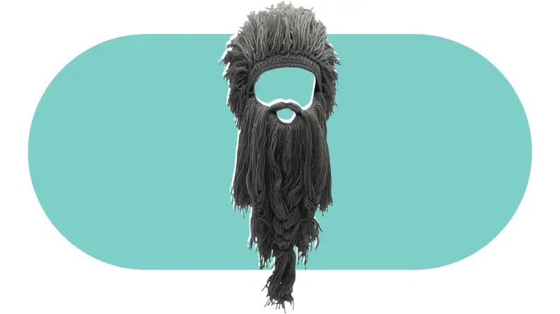 A knit hat made to look like a full head of hair with an attached oversized beard.