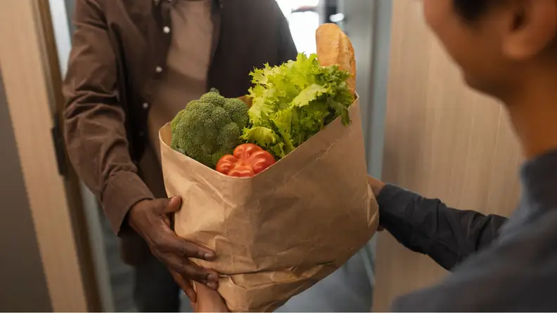 Delivery person handing groceries