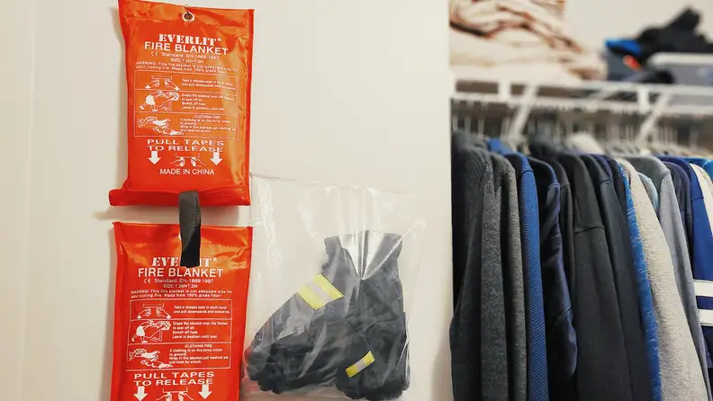 2-pack of XL Everlit Fire Blankets hanging up in closet next to gloves.