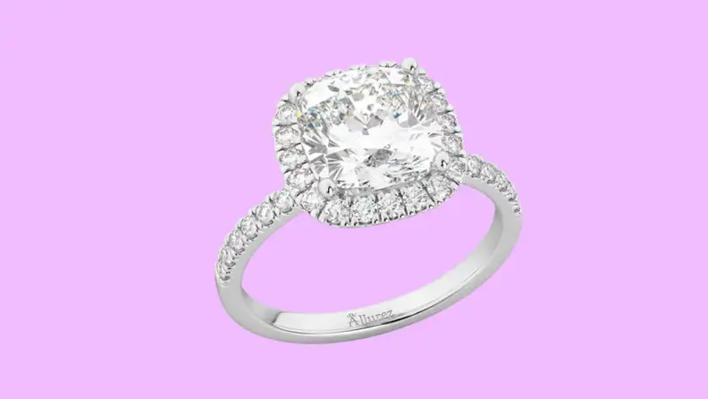 Photo of the Allurz Cushion Cut Halo Moissanite & Diamond Engagement Ring against a purple background.