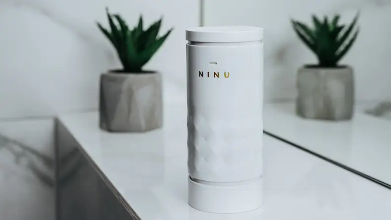 A white canister of perfume sits on a vanity.