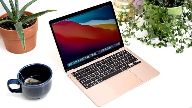 mug with tea in it and pink Apple MacBook Air
