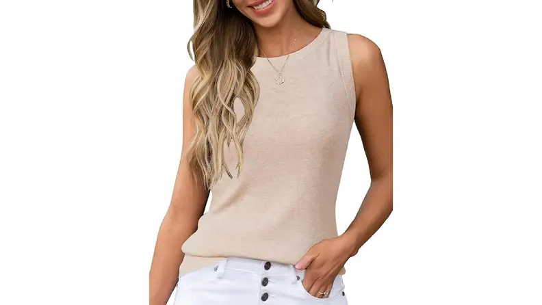 A woman wearing a light beige sleeveless knit tank top and white button-fly jeans.