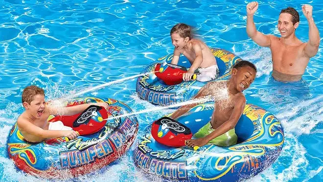 Three boys using the Banzai bumper boats in the water.