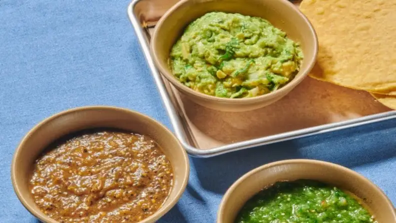 Bowls of guacamole and salsa with tortilla chips