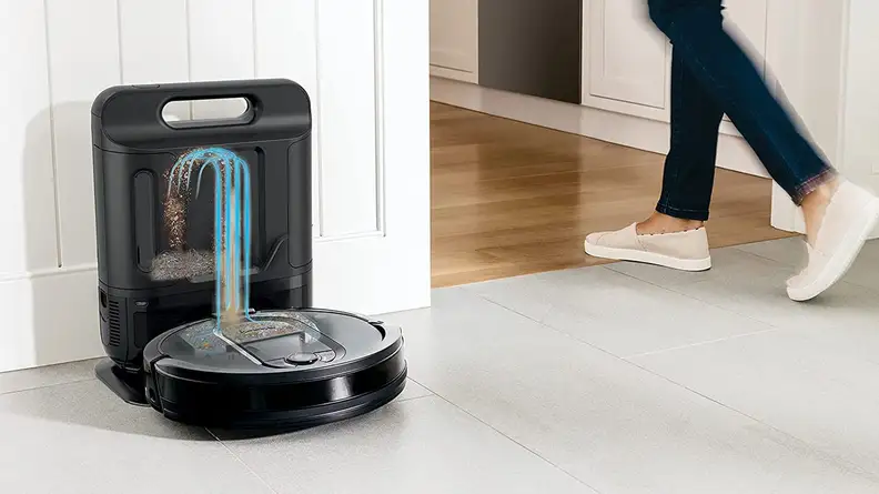Person walking by robot vacuum on floor in home.
