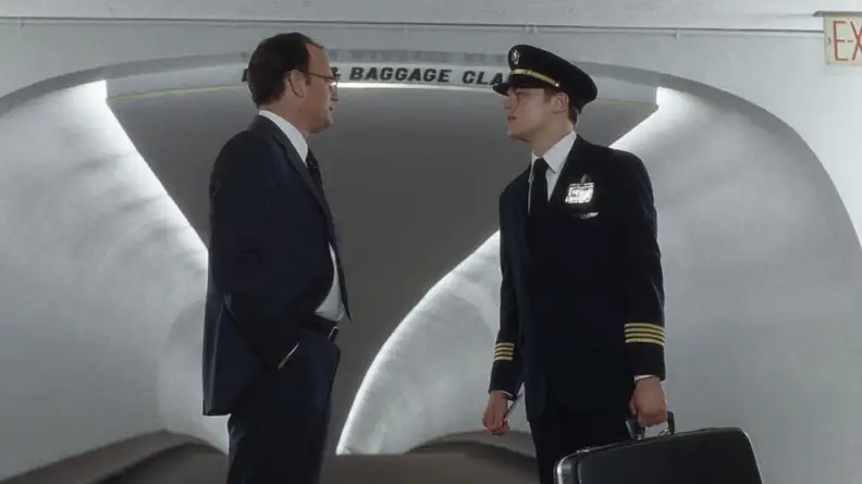 Frank (Leonardo DiCaprio) dressed as an airline pilot talking with Carl (Tom Hanks).