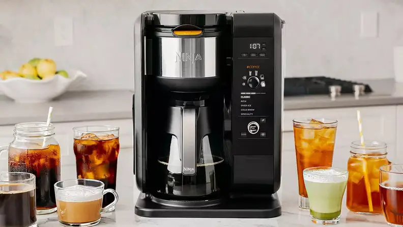 A machine brews tea on a kitchen counter.