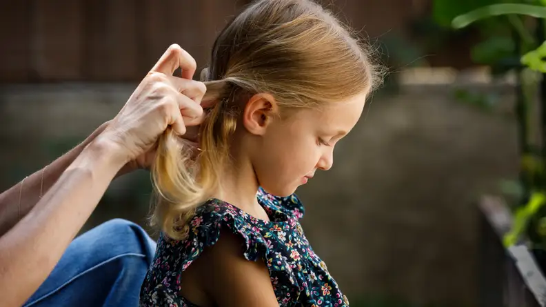 A girl getting her hair braided