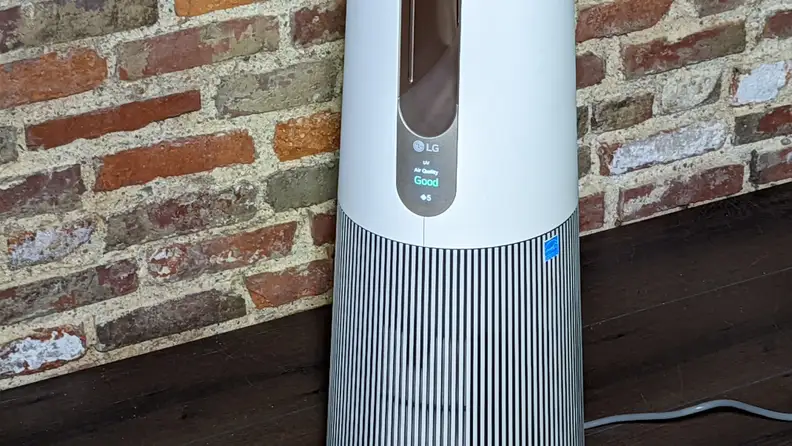 A close up of an LG PuriCare base against a brick wall.