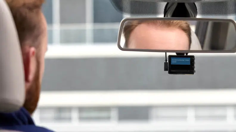 A driver glances at his vehicle's dash cam.