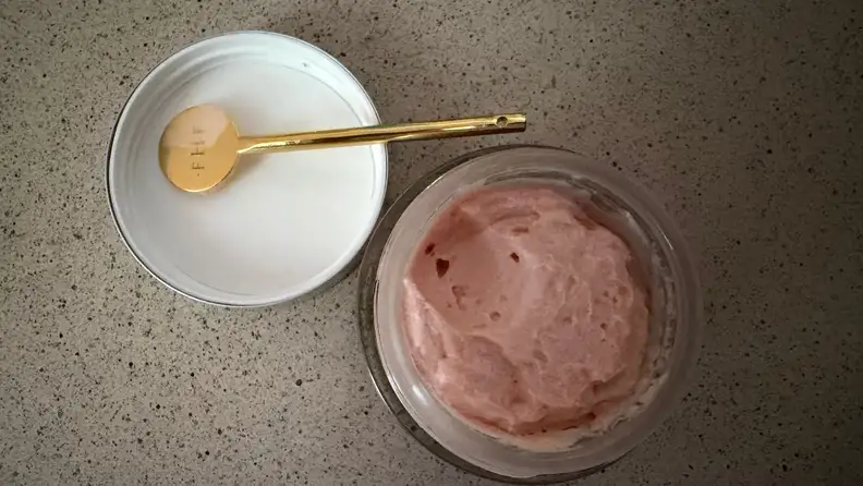 A jar of pink cream on a counter
