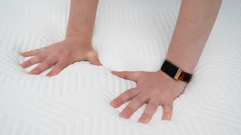 hands pressing into the surface of the Lucid mattress
