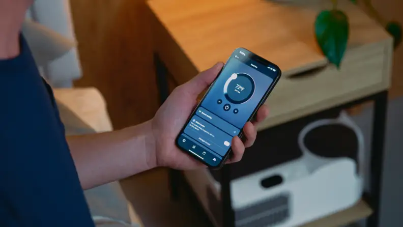 A person adjusts the Chilipad Dock Pro temperature settings using a smartphone app.