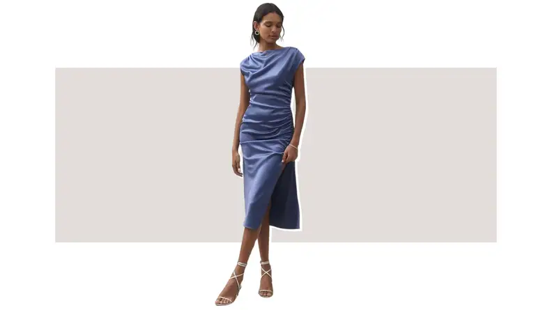 A model wearing a slate-blue dress that has a high thigh slit.