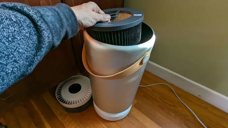 A man exposes the internal filter inside the Molekule air purifier.
