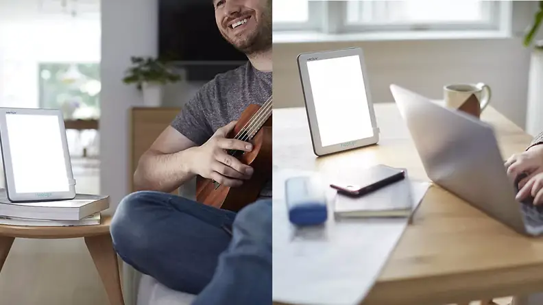 Happy light in front of someone playing the guitar and working on a laptop.