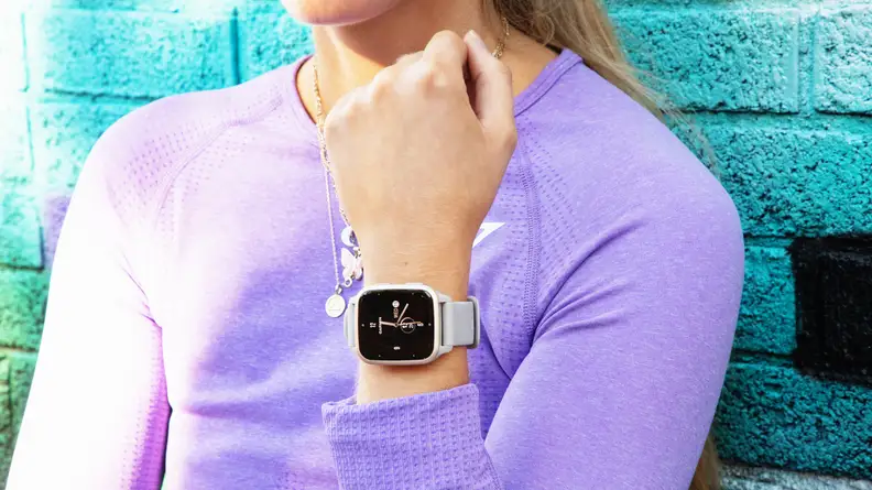 A person wearing a GarminVenu Sq 2 fitness tracker holds their wrist up to show it.