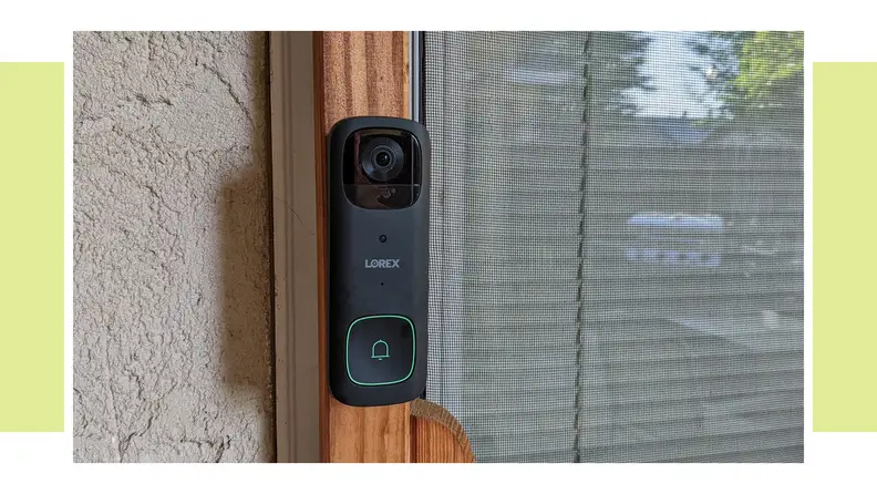 The Lorex 2K wireless doorbell hanging on the side of a home